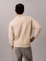 Sweater de punto de lana de alpaca cepillada, color beige, con cuello johnny y manga larga. Diseño de corte regular con puños y ruedo acanalados.