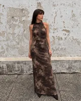 Vestido largo marrón con estampado efecto desteñido, cuello alto halter y diseño ajustado con fruncidos en el lateral.