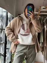 Campera de estilo casual color beige, con cierre frontal, botones a presión y puños elásticos.