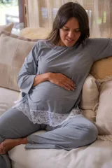 Pijama maternal gris con remera de manga larga con botones a los costados para amamantar y detalle de puntilla en el ruedo. Pantalón con calce maternal, elástico suave y lazo para ajustar la cintura.