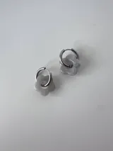 Aros de acero quirúrgico argolla con dije colgante en forma de flor de resina color gris marmoleado.