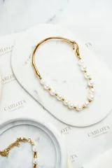 Pulsera dorada de acero quirúrgico con baño de oro 18k, decorada con perlas de agua dulce.