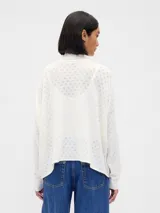 Buzo polera de punto con diseño calado pointelle, de corte holgado, cuello alto y mangas largas con puños acanalados.