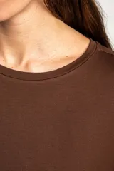 Remera de viscosa marrón, de corte oversize, con mangas cortas y cuello redondo.