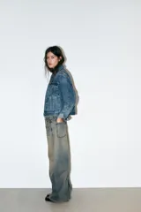 Jeans de tiro bajo con corte baggy y silueta barrel. Presenta diseño de cinco bolsillos, trabillas para cinturón y cierre frontal con cremallera y botón metálico. Confeccionado en denim con efecto de lavado desgastado.