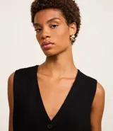 Chaleco Marfinno de corte recto y largo, confeccionado en tricot. Presenta cuello en V, cierre frontal con botones y diseño liso sin estampados.