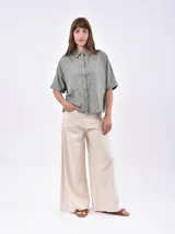 Camisa de manga corta, color rojo, con cuello camisero y botones frontales. Presenta dos bolsillos de parche en el pecho.