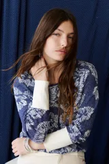 Sweater de tejido de punto con diseño floral, confeccionado en una mezcla de algodón y lurex. Presenta cuello redondo, mangas largas con puños anchos en color crema y un calce holgado.