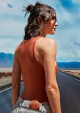 Body color marrón oscuro, confeccionado en microfibra, con escote delantero y trasero cerrado, cuerpo embolsado y gancho corsetero regulable en la entrepierna.