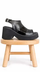 Sandalias de cuero color negro con plataforma y taco ancho, con diseño de múltiples texturas en la capellada y tira ajustable con hebilla en el talón.
