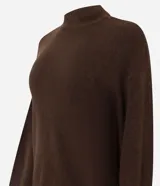 Suéter de punto color marrón chocolate, con cuello alto y mangas largas con puños ajustados. Presenta un diseño de corte corto y holgado.