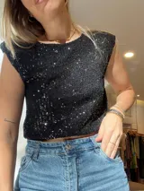 Blusa crop top negra con lentejuelas y hombreras.