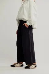 Pantalón de denim blanco de tiro medio con cintura elástica ajustable mediante cordón, bolsillos plaqué delanteros y diseño de corte amplio y holgado.