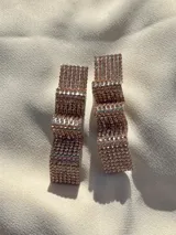 Par de aros colgantes con forma geométrica irregular, recubiertos de strass negros sobre base plateada.