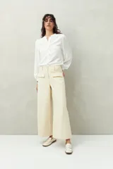 Pantalón wide leg color beige de algodón, con bolsillos delanteros con solapa y cierre con dos botones.