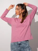 Remera rosa de manga larga, corte holgado, cuello redondo y bolsillo en el pecho.