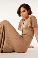 Vestido largo dorado de punto con mangas cortas con volantes, escote en V y cierre frontal con botones.