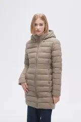 Campera acolchada color beige, de corte largo, con capucha y cierre frontal con cremallera.