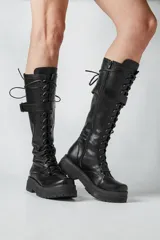 Borcegos negros de ecocuero con cordones y hebilla lateral.