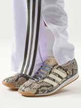 Championes Adidas SL 72 OG de perfil bajo, con empeine de cuero con estampado de piel de serpiente, tres tiras blancas laterales, cordones celestes y suela de goma estriada con entresuela de EVA y detalle en celeste.