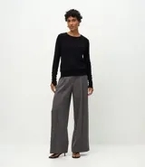 Suéter de punto ajustado con cuello redondo y manga larga. Presenta detalle de botones metalizados en los puños.