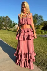 Conjunto de dos piezas compuesto por un top corto con volados en los hombros y una falda larga con múltiples niveles de volados, ambos con ajuste elástico.