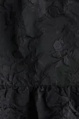 Top de breteles finos con escote recto y diseño de bajo globo con silueta abullonada. Presenta una textura sutil con relieve floral y cierre lateral oculto.