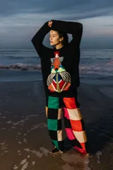 Sweater negro de lana tejido con cuello redondo, puños ajustados y bordado artesanal con figura geométrica en el frente.