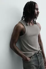 Musculosa de corte slim fit confeccionada en tejido de algodón con elasticidad, cuello redondo amplio y efecto lavado.