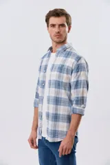 Camisa de lino de manga larga con diseño a cuadros en tonos celeste, blanco y tostado, cuello camisero y cierre frontal con botones.