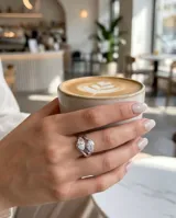 Anillo de plata 925 con diseño entrelazado y dos piedras de circonia en corte marquise.