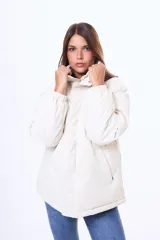 Campera tipo puffer color beige, con cuello alto, cierre frontal y puños elásticos.