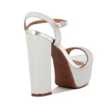 Sandalia de plataforma alta y taco grueso, color dorado brillante con textura glitter. Presenta una tira ancha en la parte delantera y una tira fina ajustable alrededor del tobillo.