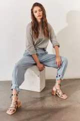 Sandalias de tacón bajo color bronce, con tiras finas cruzadas en el empeine y tiras largas para atar al tobillo. Tienen punta cuadrada y tacón de madera.