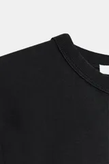 Camiseta de manga larga confeccionada en tejido de punto interlock elástico y flexible, con cuello redondo y bajo recto.