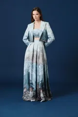 Bustier estructurado de corte spencer, confeccionado en crepe con estampado artístico de paisajes montañosos y glaciares. Presenta detalles de canutillos bordados a mano y un diseño entallado a la cintura.