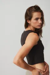 Chaleco corto de punto H&M Divided color marrón oscuro, con escote cuadrado pronunciado y cierre frontal de botones forrados. Modelo entallado con costuras princesa para definir la silueta.