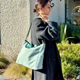 Bolso tipo tote y shopper de color negro, confeccionado en poliéster con amplio espacio interior, doble asa de mano y correa larga ajustable para llevar al hombro o cruzado.