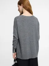 Sweater gris de cashmere con silueta relajada, cuello redondo abierto y sisa caída. Presenta detalles acanalados en el ruedo y los puños, y un sutil diseño vertical en el centro delantero.