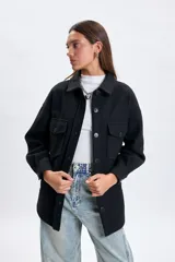 Sobrecamisa de paño en color negro, con cuello clásico, cierre frontal de botones y bolsillos frontales con solapa.