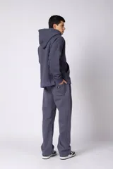 Pantalón de jogging de corte recto y fit relajado, confeccionado en tejido de algodón de color gris azulado. Presenta una caída amplia, cintura elástica y un pequeño logo bordado en la parte superior del muslo.