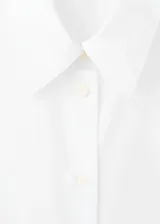 Camisa de corte clásico en popelín, con cuello camisero, cierre frontal de botones y manga larga.