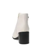 Botas de caña baja marca Bottero, confeccionadas en cuero color marfil, con taco cuadrado negro y suela a tono.