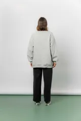 Buzo oversize de cuello redondo, confeccionado en algodón suave con interior frizado. Presenta un diseño de líneas simples, corte relajado y mangas largas con puños ajustados.