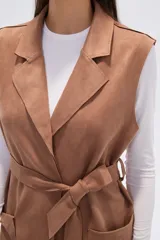 Chaleco largo de corte recto y diseño abierto, con solapas clásicas y bolsillos laterales. Confeccionado en poliéster, presenta una caída fluida y un estilo versátil ideal para superposiciones.