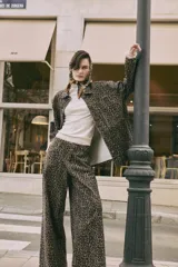 Sobrecamisa de silueta relajada con estampado animal print, cuello camisero, cierre frontal con botones y bolsillos aplicados.