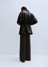 Pantalón de corte ancho, color marrón oscuro, de tiro medio y diseño fluido.