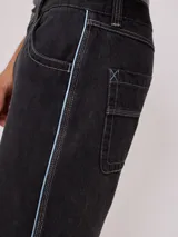 Bermuda de jean color negro con costuras en contraste color blanco y detalles bordados en celeste. Cuenta con bolsillos traseros amplios y logo de la marca bordado en uno de ellos.