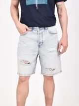 Bermuda de jean en color celeste lavado, con diseño de corte recto y detalles de roturas desgastadas en la parte frontal.