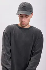 Buzo de cuello redondo en color negro con efecto lavado, de corte holgado y mangas largas con puños acanalados.